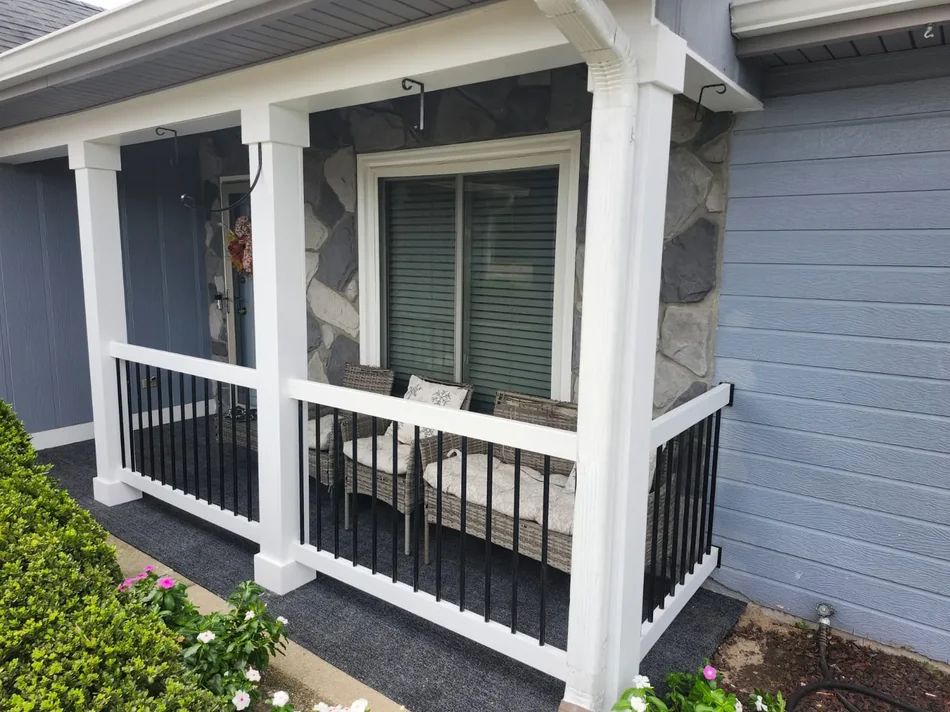 Front porch with stone column bases and black metal railing