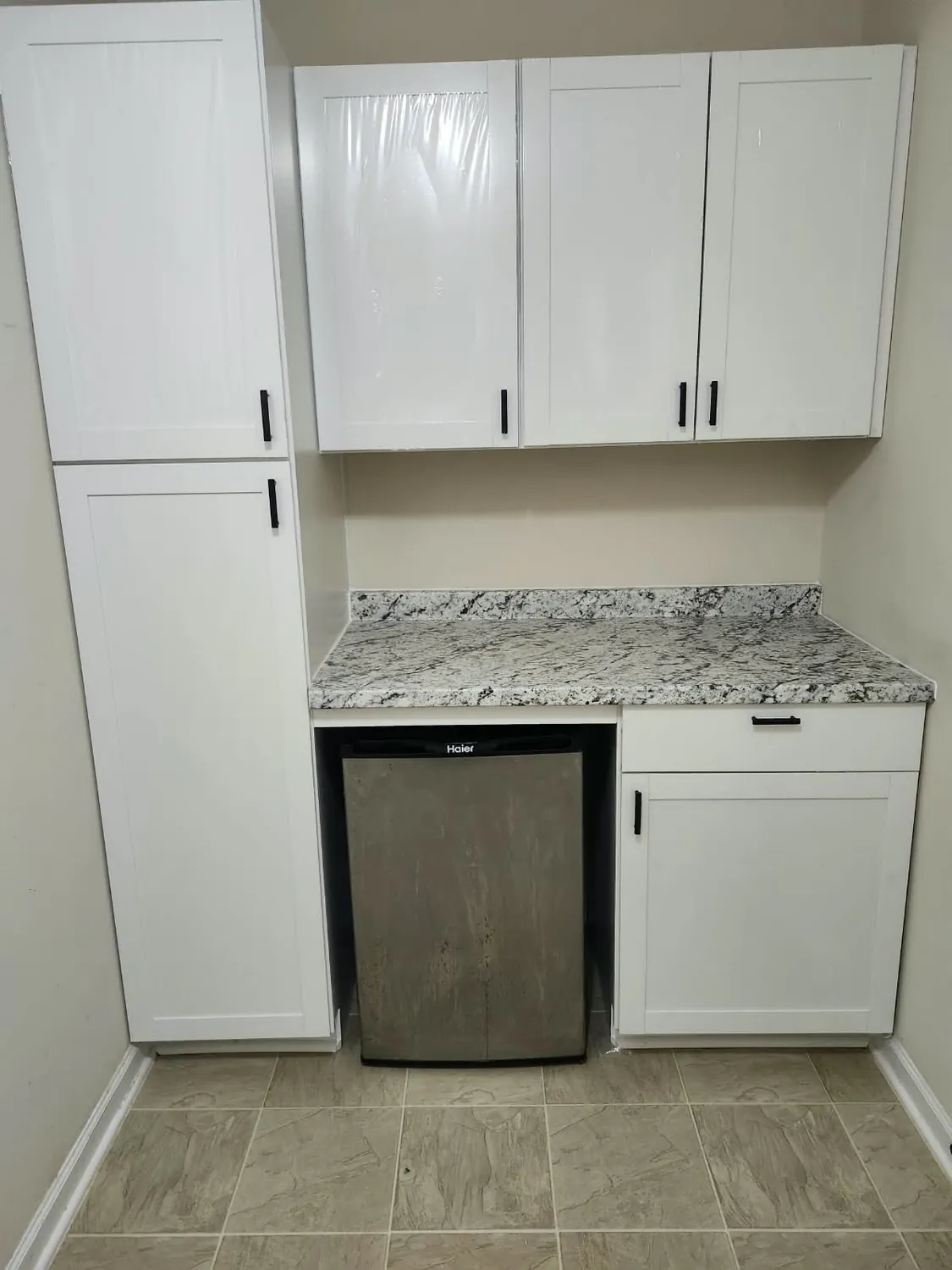 White shaker cabinets built out around a beverage fridge